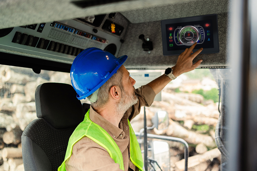 Off-highway vehicle driver using a color touchscreen in his vehicle cabin