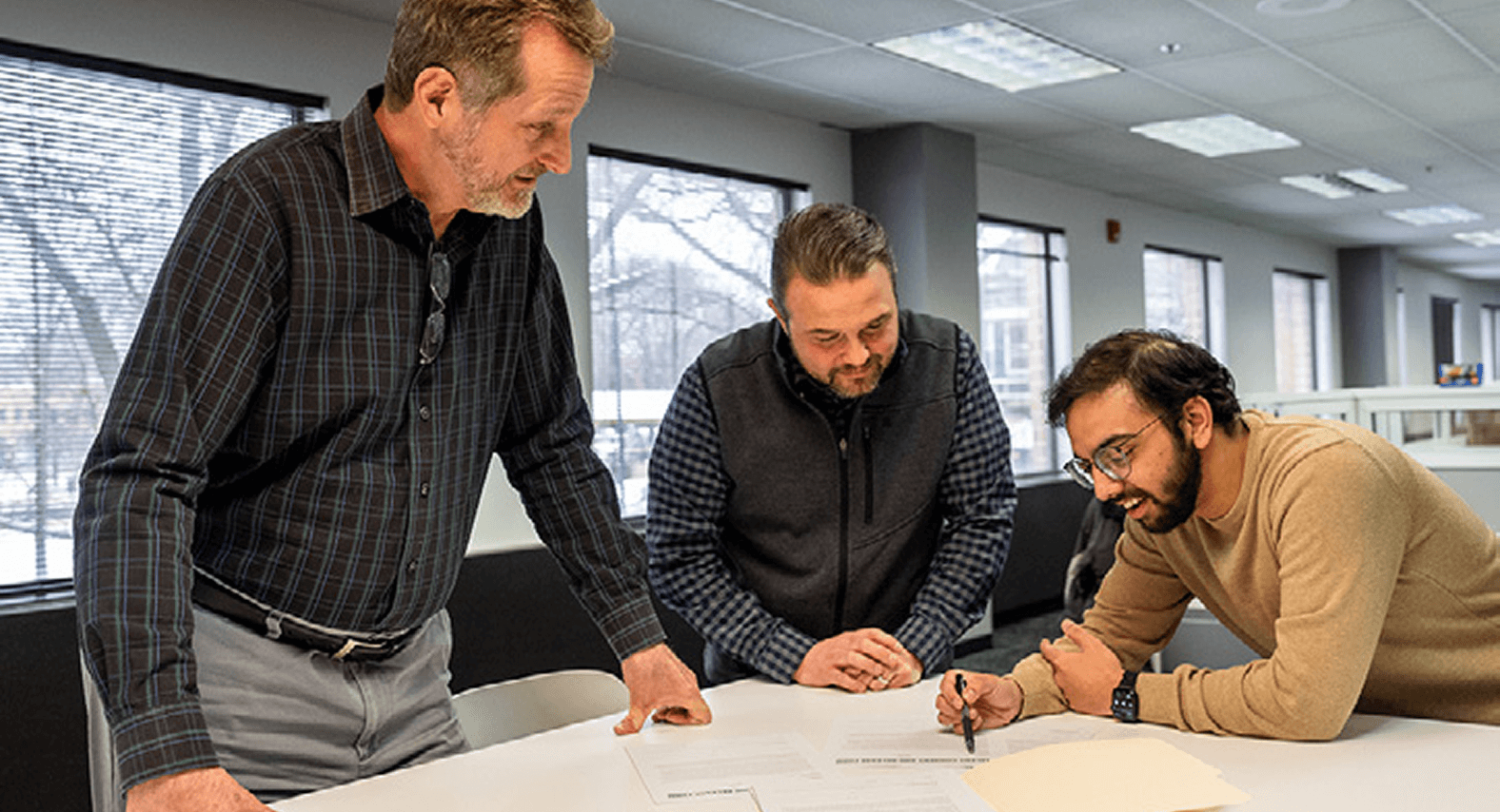Engineers collaborating with a client, closely reviewing project specifications to ensure every detail meets the customer's exact requirements.